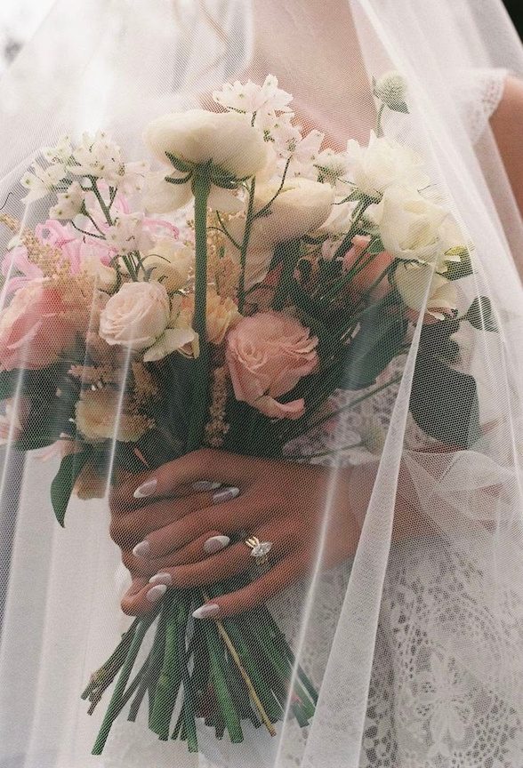 A bride holding a pastel bouquet