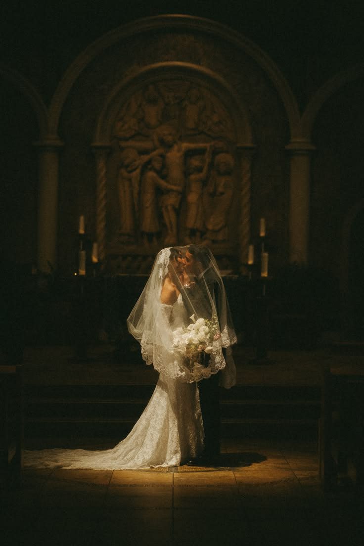 A bride standing in a candlelit chapel